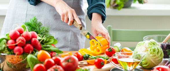 Personne découpant un poivron jaune entourée de légumes frais colorés sur un plan de travail de cuisine - Agrandir l'image, fenêtre modale