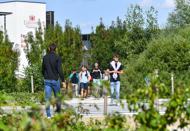 Étudiants marchant sur l'allée du Pôle Universitaire Niortais, bâtiment de l'Université de Poitiers visible en arrière-plan