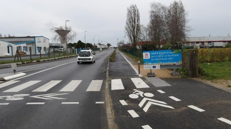 Aménagement cyclable terminé avec marquage vélo au sol et panneau Niort Agglo « territoire accessible au vélo »