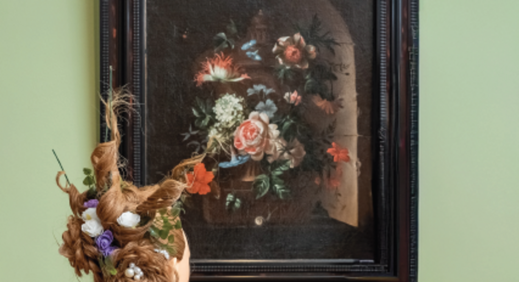 Affiche « Les collections revisitées, un parcours décoiffant » : coiffure florale élaborée devant un tableau de bouquet du musée