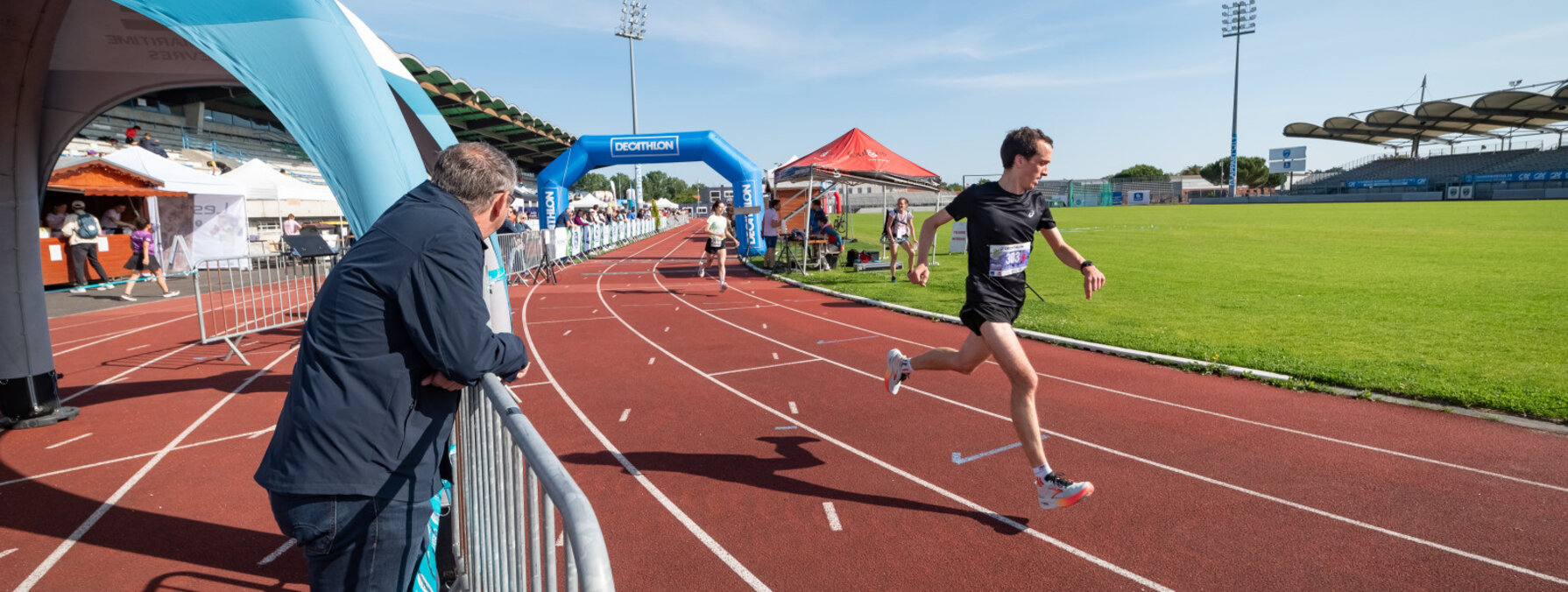 Coureur en compétition sur la piste d'athlétisme du stade