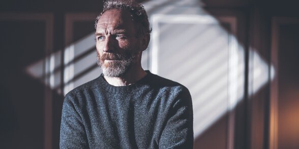 Portrait de Jón Kalman Stefánsson, auteur islandais, pull gris, regard pensif