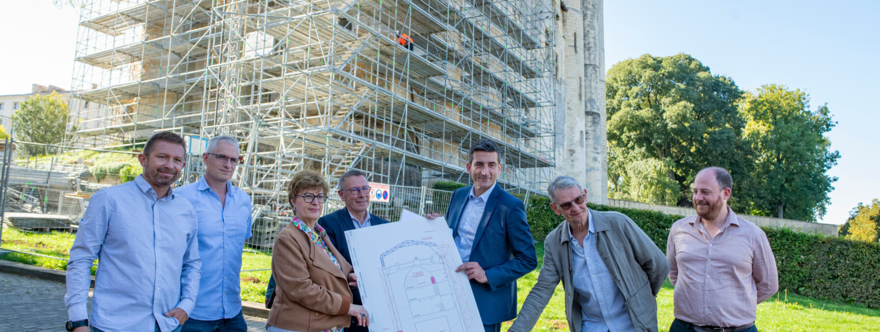 Jérôme Baloge et les acteurs du chantier consultent des plans devant l'échafaudage de la tour nord