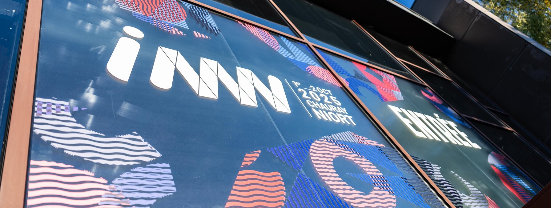 Devanture vitrée du bâtiment d'accueil avec les grandes affiches graphiques INNN 2025 à Chauray Niort