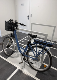 Vélo à assistance électrique stationné sur un emplacement numéroté dans le local de stationnement sécurisé